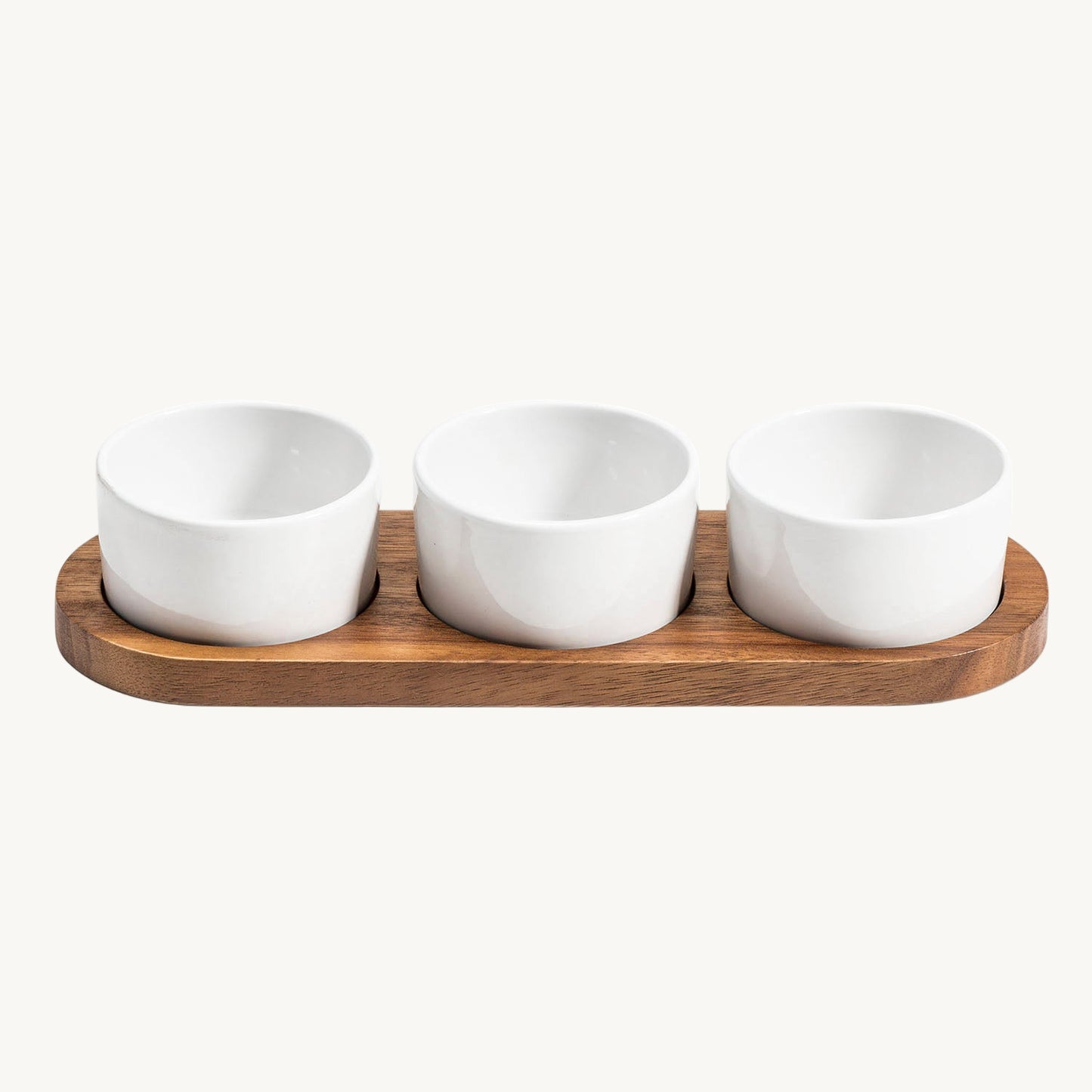 Three white ceramic bowls on a wooden tray against a white background
