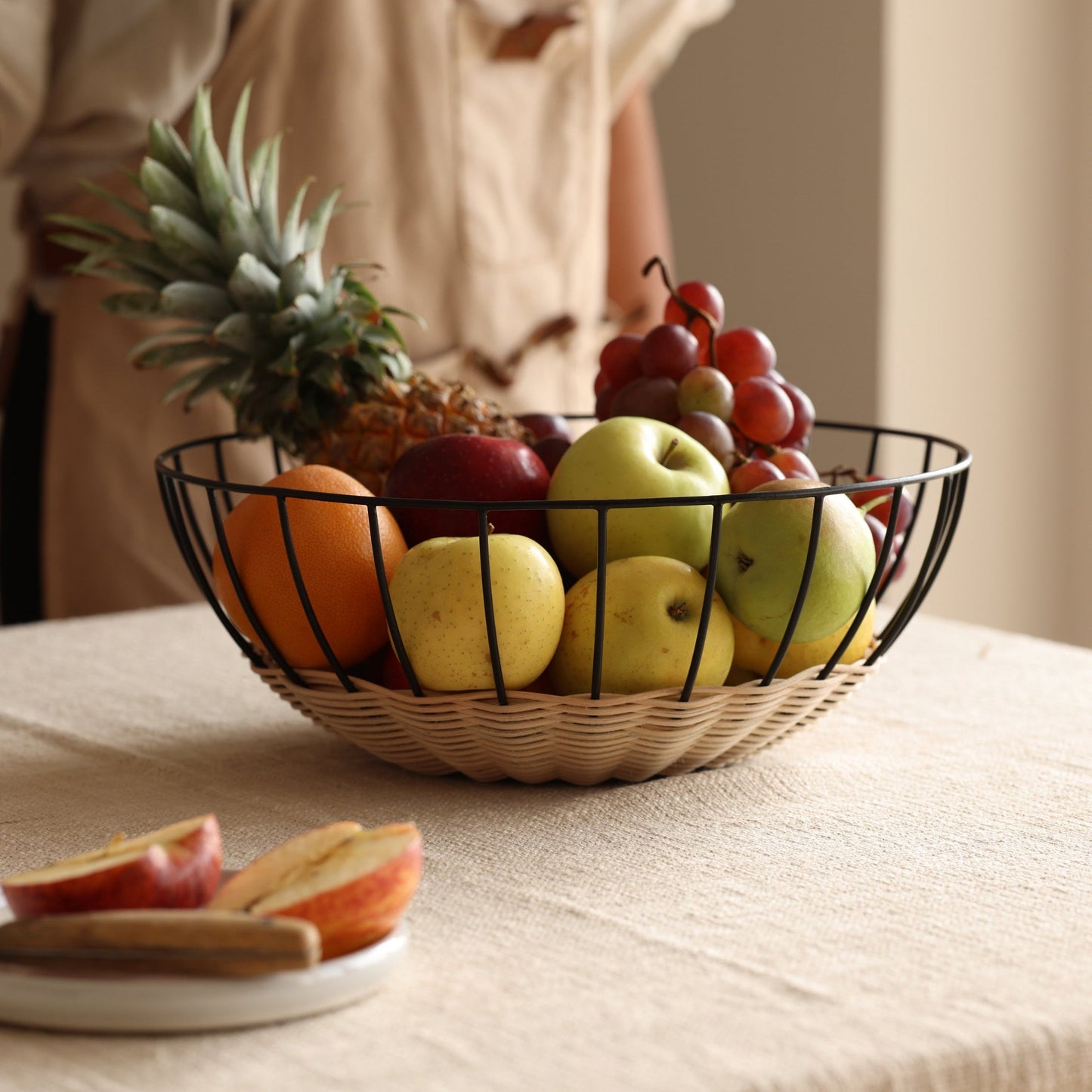 Fruit bowl with apples, oranges, and grapes on a table