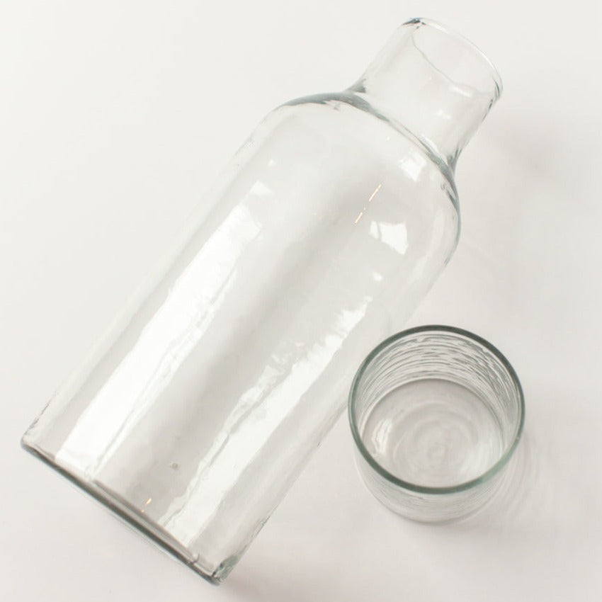 Clear glass carafe and glass on a white background