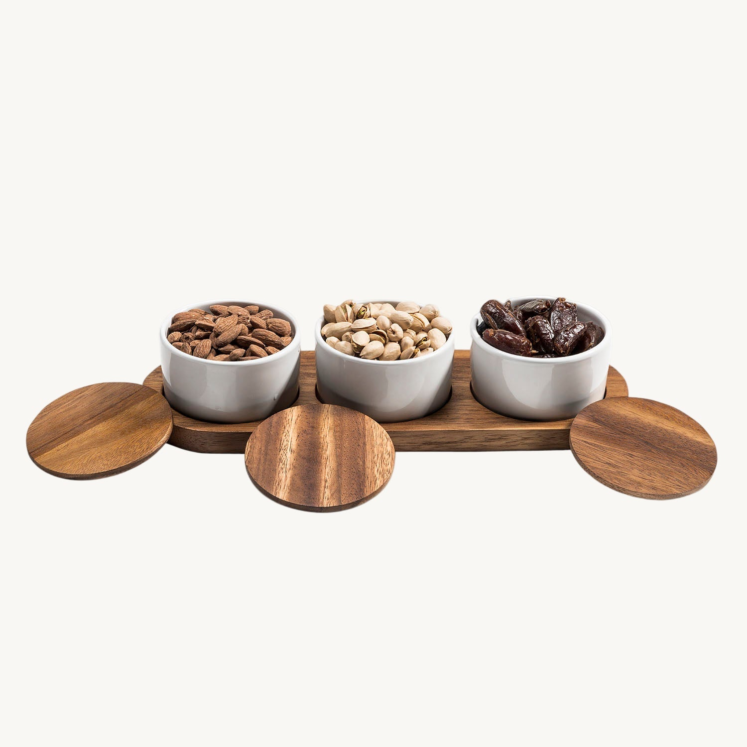 Three white bowls with different types of coffee beans on a wooden tray with lids.