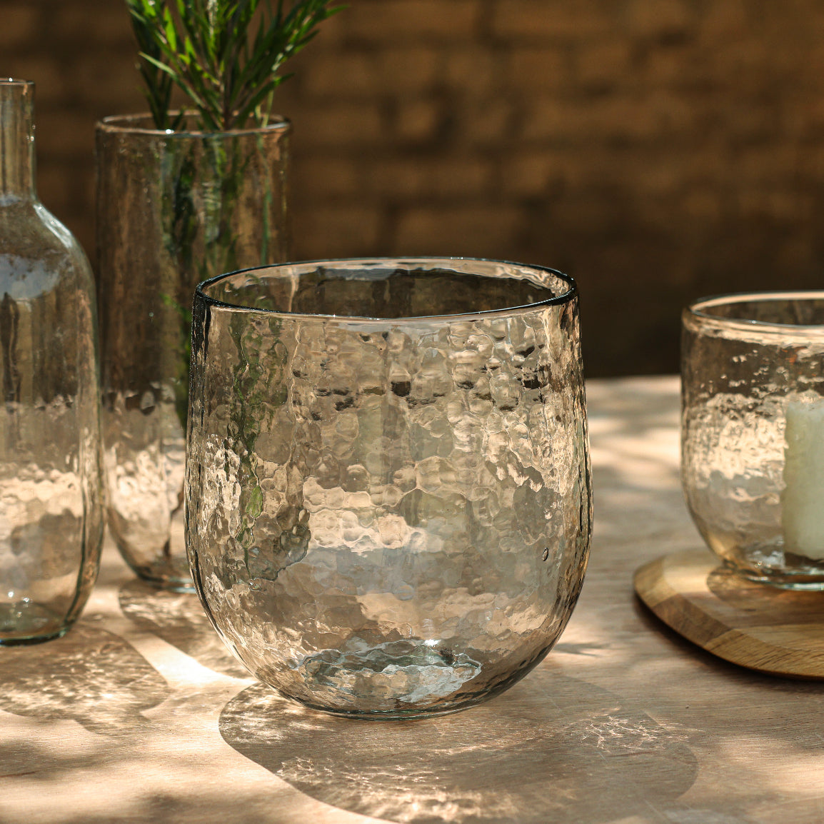 Clear glass tumblers on a wooden surface with a natural background