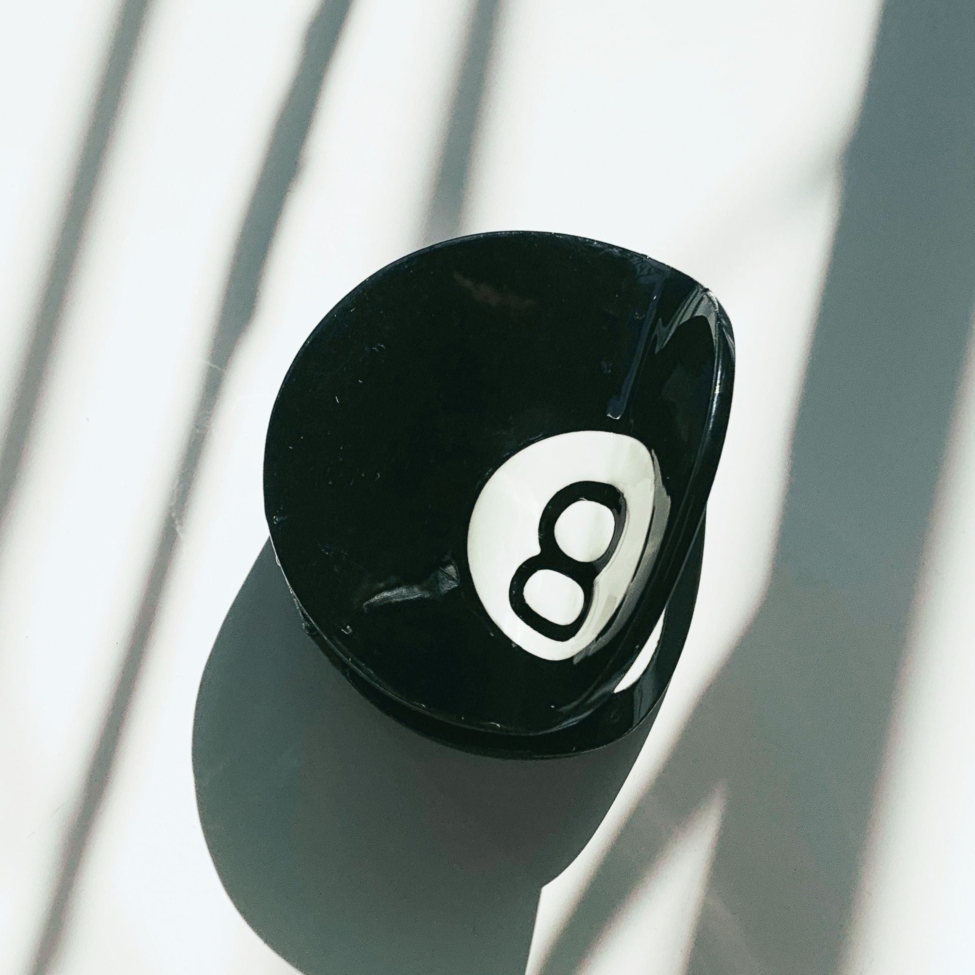 Black eight-ball on a white background with shadows