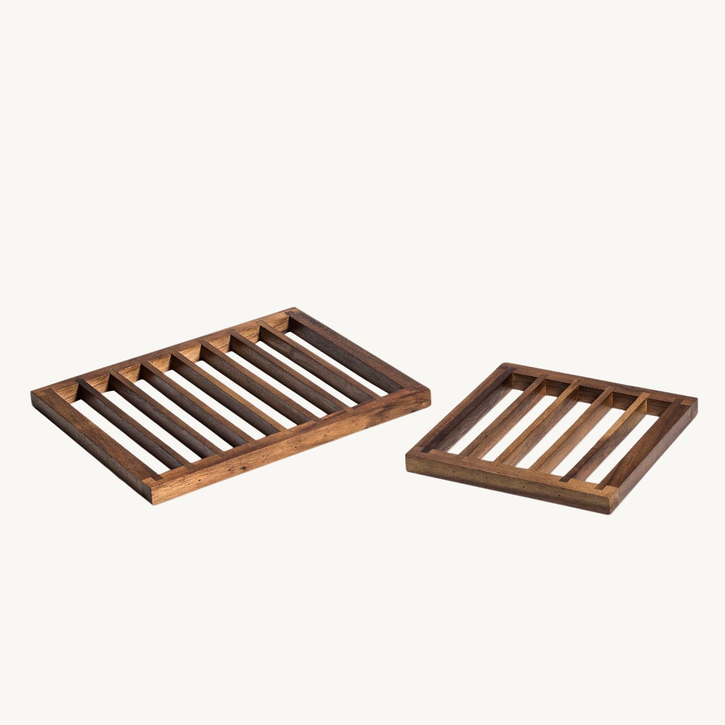 Two wooden slotted trays on a white background