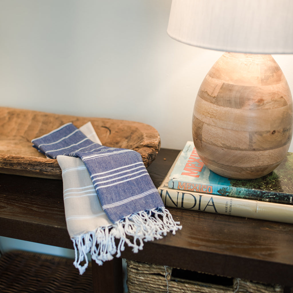 Wooden lamp on books with a blue and white towel on a wooden surface